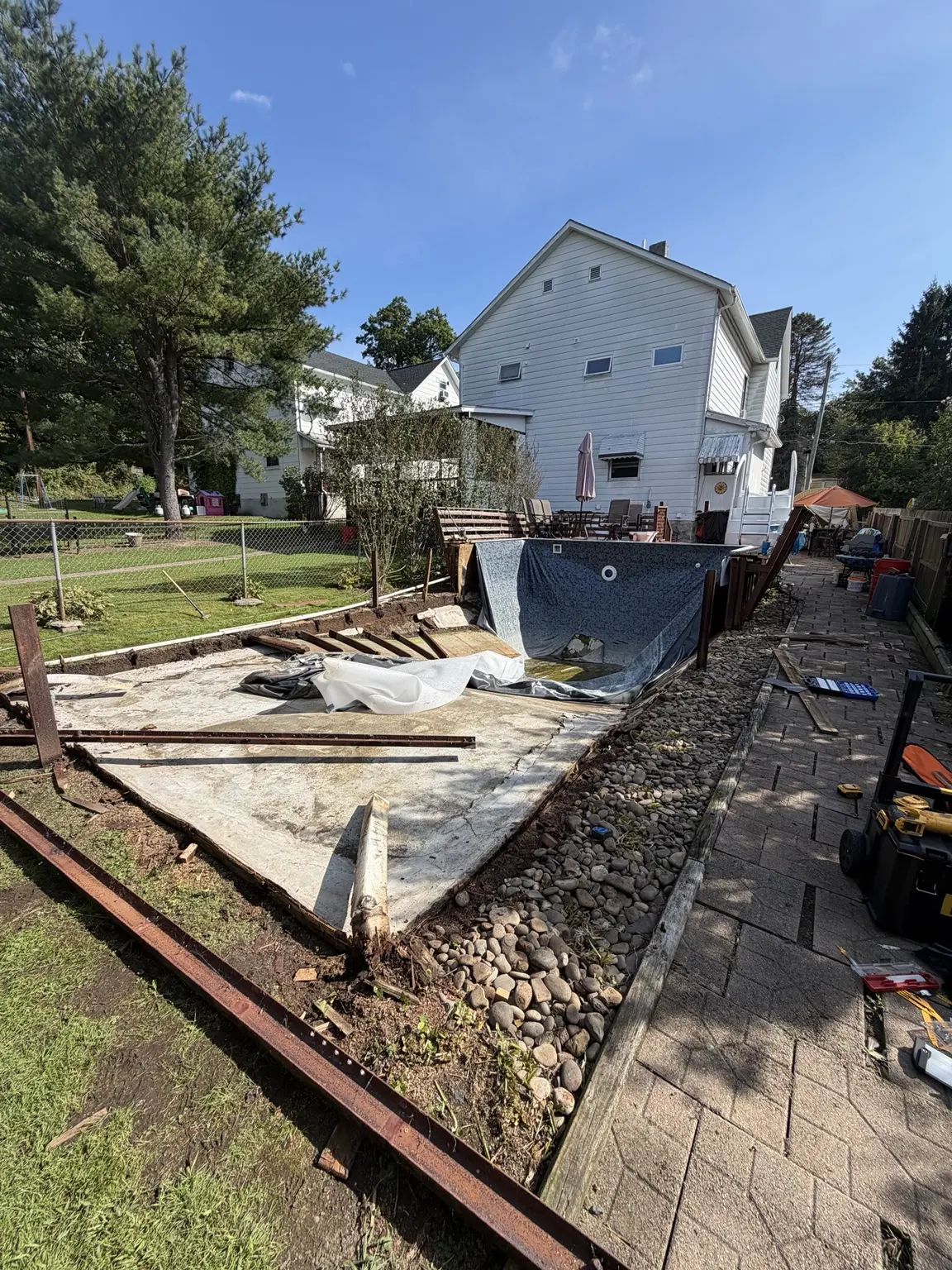 Partially dismantled wooden swimming pool and exposed concrete base