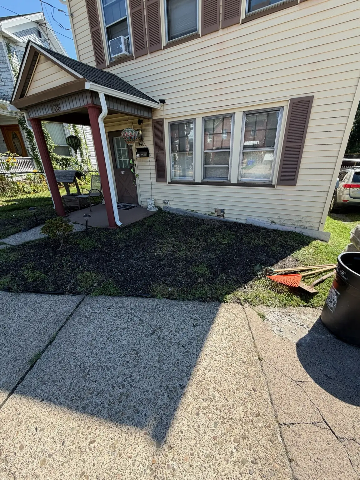 Front yard covered with old mulch and weeds before grass reseeding