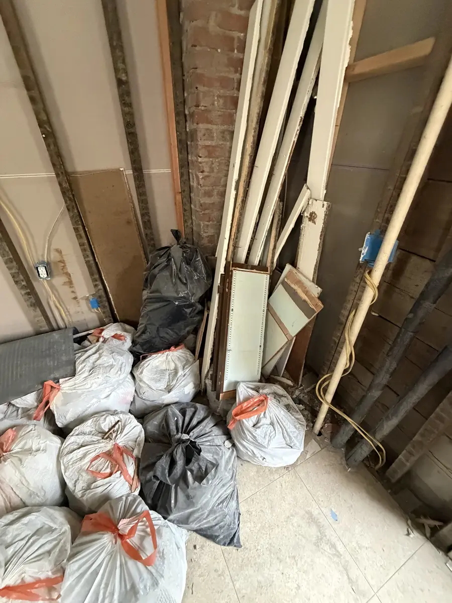 Bagged construction debris and removed wall material inside the property